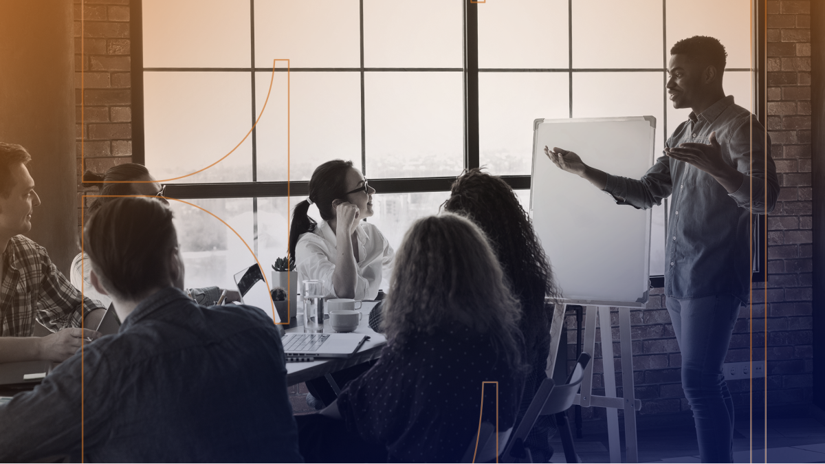 Employees in a meeting talking excitedly next to whiteboard.