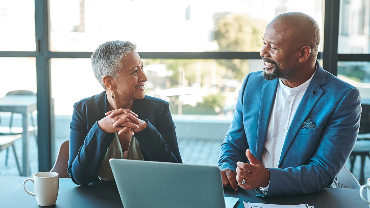 Executives share a laugh during a meeting.